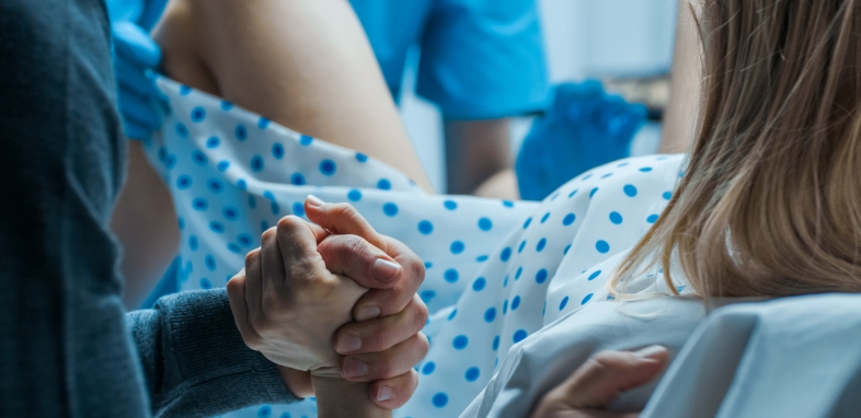 1.7 Birth Injury woman giving birth holding hand in delivery room